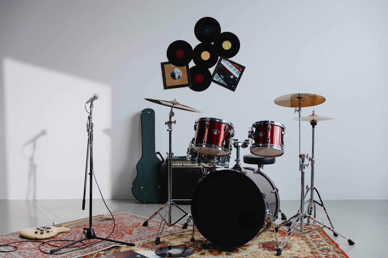 A modern music studio featuring drums, guitar, and vinyl records.